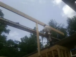 Carpenter setting a ridge beam over a new addition frame — Ice Dam Removal by Roofing Brothers in Hawk Point