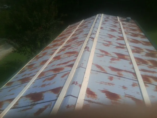 Rusted metal roof panels with new wood purlins before replacement — Storm Damage Roof Repair in Hawk Point by Roofing Brothers